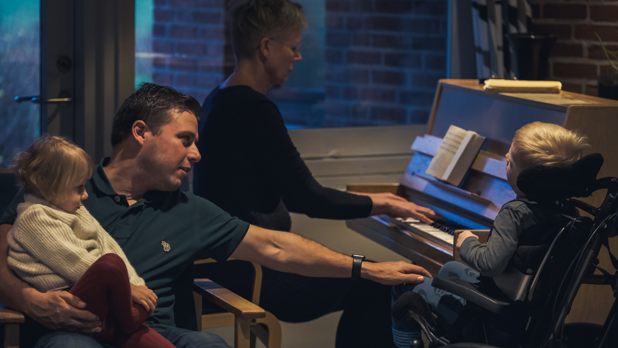 billede fra familieophold på Pindstrupcentret, hvor musikterapeuten Hilde spiller klaver